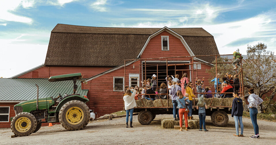 Hay wagon with people on board parked in front of main barn at Harvest Festival